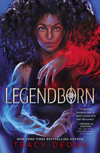 The cover of Legendborn, illustrated by Hillary D Wilson. A teenage Black girl with thick, curly hair summons magic, which materializes as red and blue flames along her arms.